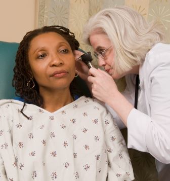 a doctor looks into the ear of her patient